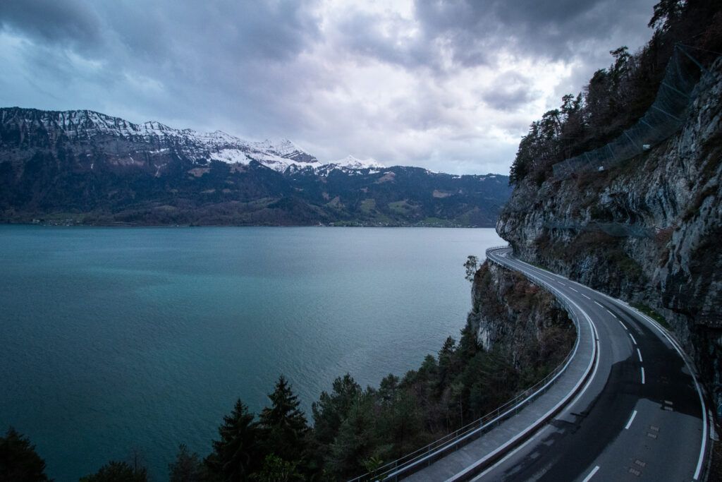 A beautiful section of road abutting a lake in the Swiss Alps. 